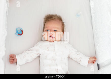 Ein neugeborenes Baby liegt in der Baumschule auf dem Bett. Stockfoto