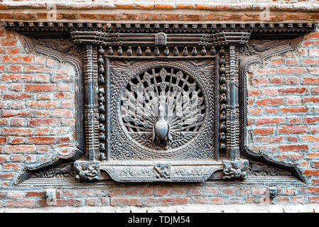 Blick auf Holz- Pfau Fenster, Tachupal Tole, Pujari Math in Bhaktapur, Tal von Kathmandu, Nepal geschnitzt. Stockfoto