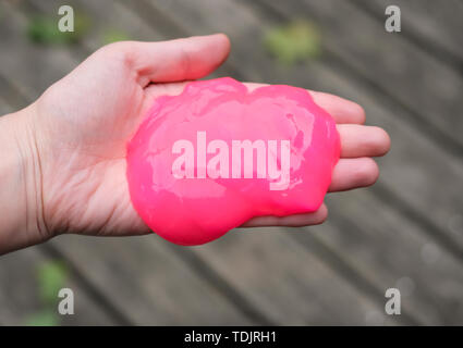 Rosa Anti stress toy Schleim in der Hand. Kampf gegen Angst und Stress. Kreative Spiel experimentieren für Kinder. Stockfoto