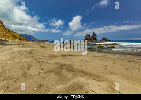 Lange natürliche Strand Benijo mit Spuren im Sand. Lava Rock im Wasser. Blue Sea Horizon, natürliche Himmel Hintergrund Stockfoto