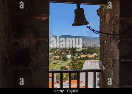 Blick durch das Fenster der Kirche Turm der historischen Stadt San Cristobal de La Laguna auf Teneriffa, der die Gebäude und Straßen mit Berg Stockfoto