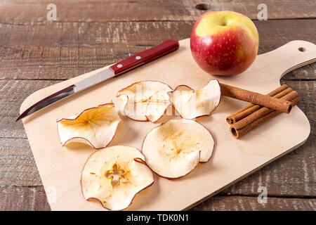 Vorderansicht getrocknete Apfel Chips, Raw apple Cinnamon Sticks auf dem Kochen über Holz Hintergrund. Stockfoto