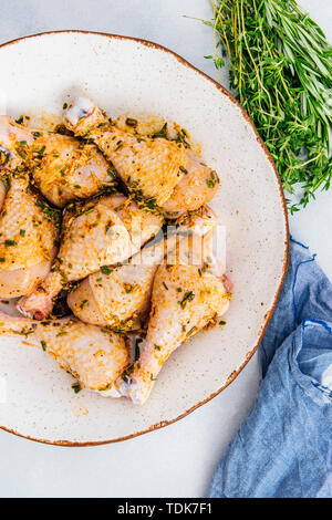 Chicken Drumsticks mit Kräutern mariniert in einer Keramikschale Stockfoto