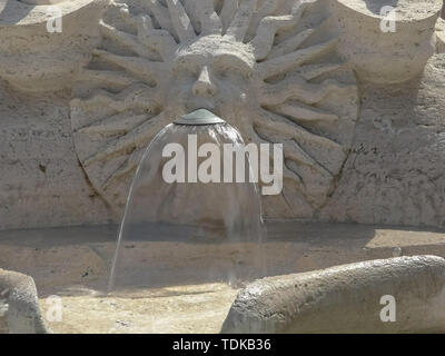 Nahaufnahme der Wasser aus einem Sun-förmige menschliches Gesicht auf der häßlichen Boot Brunnen an der Spanischen Treppe in Rom, Italien Stockfoto