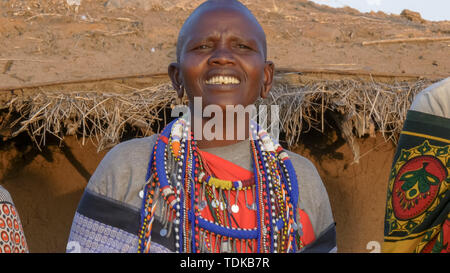 Nahaufnahme der eine Massai-frau tragen graue Kleidung und traditionellen Schmuck Singen in einem Dorf in der Nähe von Masai Mara in Kenia Stockfoto