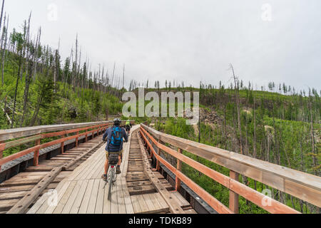 Paar Radfahren auf einem der vielen Gerüste der Kettle Valley Railway (KVR) eine verlassene Eisenbahn zu einem Wander-/Radweg umgewandelt. Stockfoto