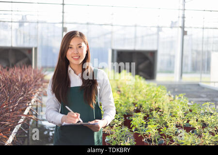 Junge schöne chinesische Frau arbeitet im grünen Bereich Stockfoto