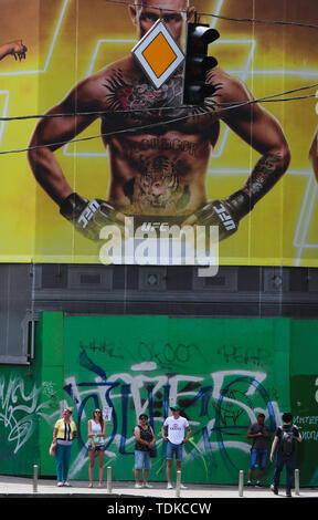 Kiew, Ukraine. 16 Juni, 2019. Die Menschen warten auf die Straße unter dem Plakat mit dem Portrait eines irischen professionelle Mixed Martial Artist und Boxer Conor McGregor an Khreshchatyk Straße in Kiew, Ukraine, Juni 16, 2019 Credit zu überqueren: sergii Kharchenko/ZUMA Draht/Alamy leben Nachrichten Stockfoto