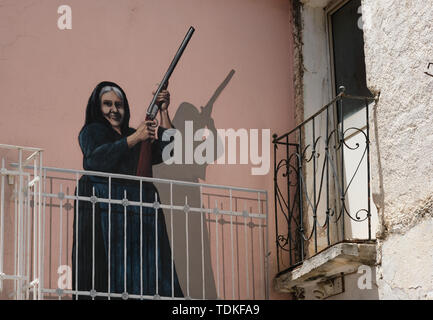 Perugia, Italien. 08 Juni, 2019. Eine Wand malen auf einer Hauswand, Maria Palimodde des Künstlers Luigi Columbu ist eines der berühmten großformatige Wandbilder 'Murales' in den Straßen der Region gemalt. Themen sind sowohl internationale Ereignisse wie den Vietnamkrieg, die partisanen Kämpfen während des Faschismus und lokale Veranstaltungen. Eine der wichtigsten ist der erfolgreiche Kampf der Bevölkerung gegen ein Truppenübungsplatz der NATO im Jahre 1969 geplant Auf der Pratobello Plateau. Foto: Jens Kalaene/dpa-Zentralbild/ZB/dpa/Alamy leben Nachrichten Stockfoto