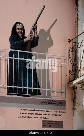 Perugia, Italien. 08 Juni, 2019. Eine Wand malen auf einer Hauswand, Maria Palimodde des Künstlers Luigi Columbu ist eines der berühmten großformatige Wandbilder 'Murales' in den Straßen der Region gemalt. Themen sind sowohl internationale Ereignisse wie den Vietnamkrieg, die partisanen Kämpfen während des Faschismus und lokale Veranstaltungen. Eine der wichtigsten ist der erfolgreiche Kampf der Bevölkerung gegen ein Truppenübungsplatz der NATO im Jahre 1969 geplant Auf der Pratobello Plateau. Foto: Jens Kalaene/dpa-Zentralbild/ZB/dpa/Alamy leben Nachrichten Stockfoto