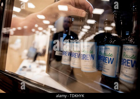 Berlin, Deutschland. 17 Juni, 2019. Auf der IWA die Wiederverwendung von Wasser 2019 Konferenz, ein Mann nimmt Bier aus Abwasser aus einem Kühlschrank im Xylem Unternehmen gebraut. Mit Bier aus Abwasser, eine Firma aus Herford will ein Beispiel für die Verwendung von recycelten Abfälle Wasser zu setzen. (Zu dpa-KORR' von Kläranlage zu tippen: Bier aus Abwasser") Credit: Christoph Soeder/dpa/Alamy leben Nachrichten Stockfoto