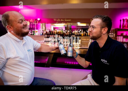 Berlin, Deutschland. 17 Juni, 2019. Abbildung - jan-karl Nielebock (l), Brauerei Engineer bei Xylem, Jens Scheideler, Product Manager die Wiederverwendung von Wasser bei Xylem, Toast, die auf der Konferenz IWA Wiederverwendung von Wasser 2019 mit Bier aus Abwasser gebraut. Credit: Christoph Soeder/dpa/Alamy leben Nachrichten Stockfoto