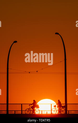 Magdeburg, Deutschland. Juni, 2019 18. Radfahrer überqueren Sie eine Brücke bei Sonnenaufgang. Die Region rund um die Landeshauptstadt ist mit einem warmen, sonnigen Sommertag. Am späten Nachmittag sollte die Temperatur über 30 Grad Celsius liegen. Credit: Klaus-Dietmar Gabbert/dpa-Zentralbild/ZB/dpa/Alamy leben Nachrichten Stockfoto