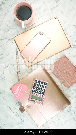 Feminine Schreibtisch Arbeitsbereich mit Rose Gold Zubehör auf weißem Marmortisch, flatlay Overhead. Stockfoto