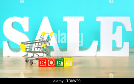 Ende des Geschäftsjahres Umsatz shopping Konzept mit mini Warenkorb und großen Verkauf Buchstaben. Stockfoto