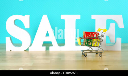 Ende des Geschäftsjahres Umsatz shopping Konzept mit mini Warenkorb und großen Verkauf Buchstaben. Stockfoto