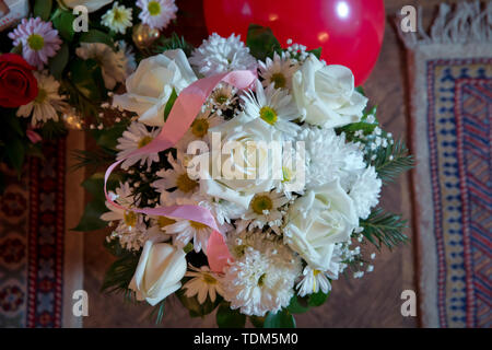 White Bouquet. Mit einem rosafarbenen Band verbunden. Handgefertigte hite Bouquet Rose In der Liebe hart-Form Valentine in Nahaufnahme Stockfoto