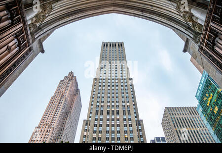 New York, Manhattan kommerziellen Zentrum. Wolkenkratzer Perspektive gegen den blauen Himmel Hintergrund, Low Angle View aus einem klassischen arch Stockfoto