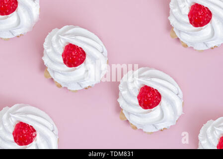 Luftig protein Gebäck Korb mit roten Himbeeren auf hölzernen Tisch Hintergrund. Flach Stockfoto