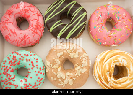 Verschiedenen donuts liegen in Feld Stockfoto