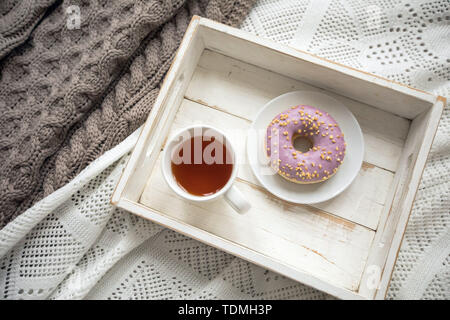 Holz- Tablett mit Kaffee und Donut Stockfoto