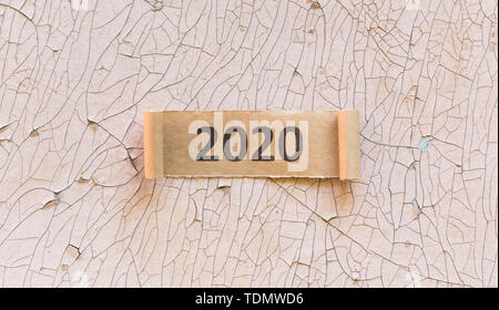 2020 text auf Torned curly Blatt braunes Papier auf alten Wand Stockfoto