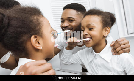 Kleine Tochter und Vater die Zähne putzen Zusammen Stockfoto