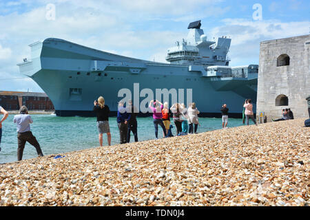 Gratulanten Welle aus der Royal Navy Flugzeugträger HMS Queen Elizabeth, wie es durch den Mund von Portsmouth Hafen segelte, Segel für Meer Studien. Stockfoto