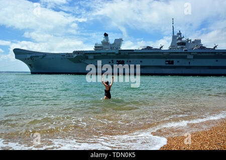 Schwimmer Dale Marie Wellen aus der Royal Navy Flugzeugträger HMS Queen Elizabeth, wie es durch den Mund von Portsmouth Hafen segelte, Segel für Meer Studien. Stockfoto