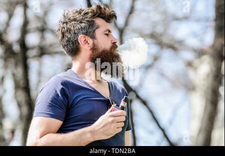 Hipster Mann vaping Gerät. Mann Rauchen E-Zigarette. Gesundheit, Sicherheit und Sucht. Dämpfe einatmen. Reifen Hipster mit Bart. Bärtige brutalen Mann rauchen elektronische Zigarette. Sieht gut aus. Stockfoto