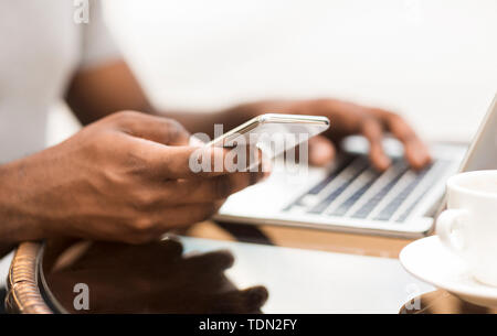 Tausendjährigen afrikanischen amerikanischen Mann mit Handy während der Arbeit Stockfoto