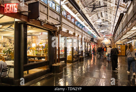 New York, Chelsea Market. Innenansicht der Eingangshalle, Menschen zu Fuß, beleuchtete Stores Stockfoto