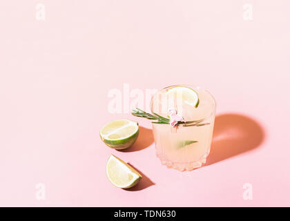 Ein erfrischendes Getränk von Zitrone und Limette Limonade transparente Glas auf einem rosa Hintergrund hellem Sonnenlicht. Sommer cocktail Stockfoto