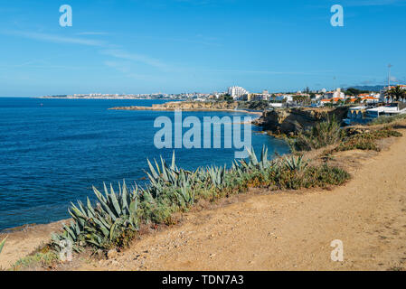 Portugiesische Riviera in der Nähe von Lissabon mit Resort Stadt Cascais sichtbar im Hintergrund und die Berge von Sintra nach rechts. Cactus im Vordergrund Stockfoto