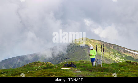 Guy touristische startet drone in den Bergen Stockfoto