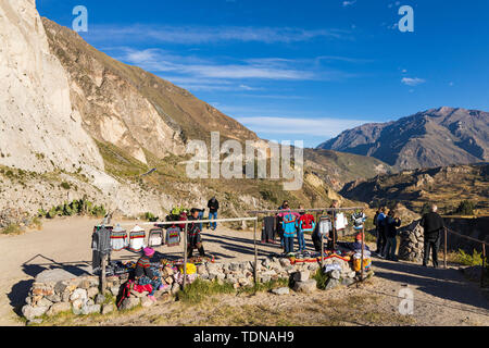 Lokale Damen verkaufen gewebten und gewirkten bunte Kleidung an einem Aussichtspunkt entlang des Randes der Colca Canyon, Peru, Südamerika Stockfoto