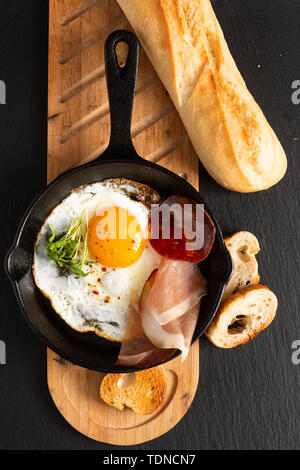Essen Frühstück Konzept Spiegelei in der Pfanne eiserne Pfanne mit Flachs Sprossen und Speck mit Kopie Raum Stockfoto
