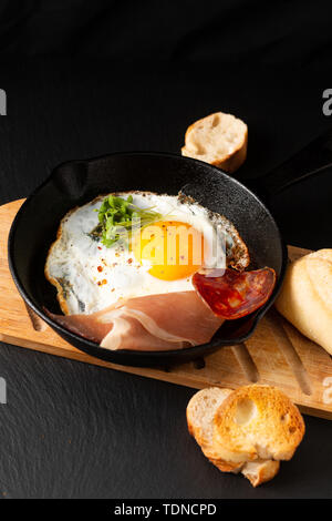 Essen Frühstück Konzept Spiegelei in der Pfanne eiserne Pfanne mit Flachs Sprossen und Speck mit Kopie Raum Stockfoto