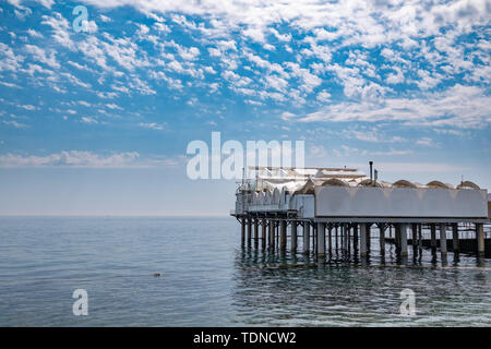 Plattform unterstützt im Meer in der Nähe der Küste. Niedrige dichte Wolken über dem Meer. Stockfoto