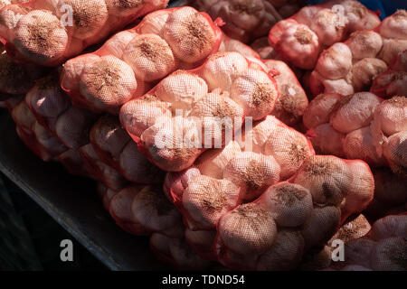 Knoblauch auf Mesh bag bei Farmers Market. Im Freien, sonnigen Tag Stockfoto