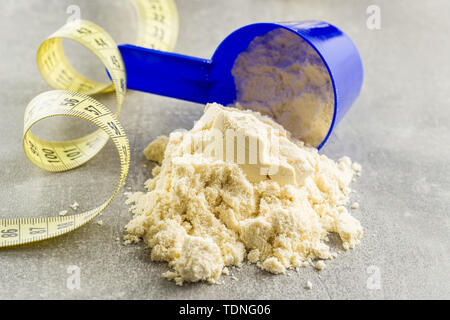 Whey Protein Pulver in Schaufel und Maßband. Stockfoto