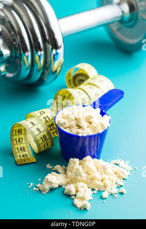 Whey Protein Pulver in Schaufel und Maßband. Stockfoto