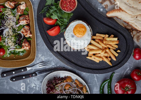 Rindersteak mit Ei und Salat aus grünen und Gemüse. Holz- Hintergrund, Tisch, Fine Dining Stockfoto