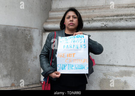 Demonstrator hält ein Plakat, das liest kolumbianischen Aktivisten Bauern sind keine Verbrecher stoppen die Tötung während des Protestes. Die Demonstranten versammelten sich vor Gibson Halle gegen kolumbianische Präsident Ivan Duque Besuch in London zu protestieren. Sie sind an die kolumbianischen rechten Regierung und der mangelnde Schutz der kolumbianischen Gesellschaft, die systematisch in Kolumbien in den letzten Jahren getötet wurden. Sie fordern Schutz für die Gesellschaft und die Umsetzung der Friedensabkommen mit den demobilisierten FARC. Demonstranten platziert eine 50 m lange Banner auf dem Bürgersteig außerhalb Gibson Stockfoto