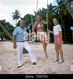 Die deutsche Fernsehmoderatorin, Programmsprecherin, Plant und ehemalige Miss World Petra Schürmann posiert schaukelnd, mit Ihrem Partner Gerhard Freund und Tochter Alexandra Freund am Strand im Bikini, Ca. 1978. Die deutsche TV-Moderator, Sprecher, Schauspielerin und ehemalige Miss World Petra Schürmann stellt mit ihrem Partner Gerhard Freund und Tochter Alexandra Freund am Strand im Bikini, Ca. 1978. Stockfoto