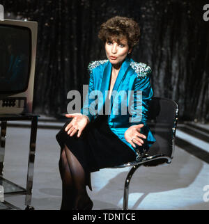 Deutsche Fernsehansagerin und Moderatorin Carolin Reiber auf der Bühne bei einer Fernsehshow, Deutschland sterben kann. 1989. Das deutsche Fernsehen Ansager und Moderatorin Carolin Reiber auf der Bühne in einer TV-Show, Deutschland Ca. 1989. Stockfoto