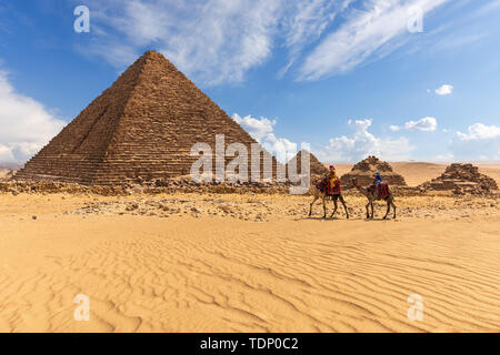 Die Pyramide des Menkaure mit drei Pyramiden der Königinnen und Beduinen in der Nähe von ihnen. Stockfoto