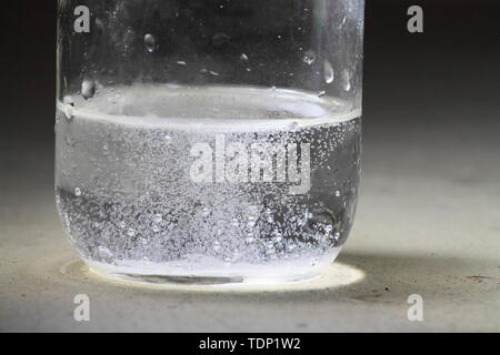 Nahaufnahme einer Essig und Backpulver Reaktion in der Unterseite von einem Glas geschieht; flüssige meistens frei mit Blasen Stockfoto