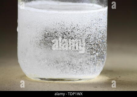 Nahaufnahme einer Essig und Backpulver Reaktion in der Unterseite von einem Glas geschieht; heftige Reaktion mit vielen Blasen Stockfoto