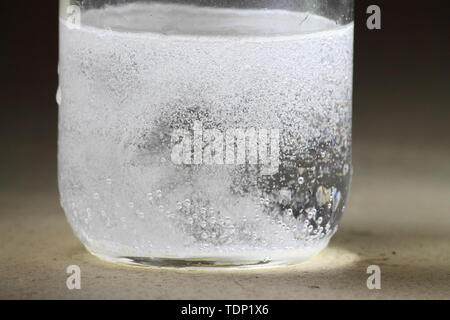 Nahaufnahme einer Essig und Backpulver Reaktion in der Unterseite von einem Glas geschieht; heftige Reaktion mit vielen Blasen Stockfoto